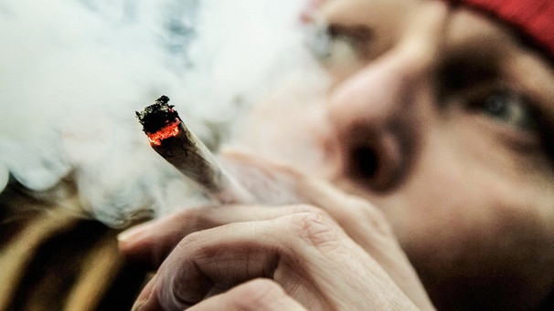 Eine Frau raucht einen Joint. Cannabis-Konsum ist in Deutschland und europaweit in den vergangenen Jahren angestiegen. Die Legalisierung von Cannabis ist umstritten. Was ist der Unterschied zwischen Cannabis, Hanf, Marihuana und CBD? Zwar kann Cannabis in manchen Fällen einen medizinischen Nutzen haben - doch spricht das auch für die Freigabe des "Freizeit-Konsums"? Wir erklären euch, welche Folgen das für den Einzelnen und die Gesellschaft haben könnte. | Bild: picture-alliance/dpa