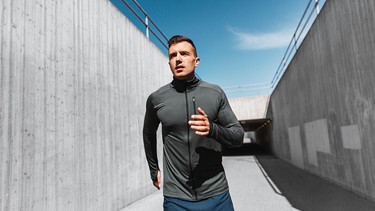 Junger Mann joggt. Laufen begeistert uns. Es ist nicht nur Sport, sondern auch Ausgleich. Joggen tut Körper und Seele gut. Doch wie hat sich das Laufen historisch entwickelt? | Bild: picture alliance / Zoonar | lev dolgachov