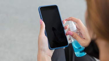 Die größte Keimschleuder zu Hause ist der Spülschwamm. Auch auf dem Smartphone können Keime sein. Die Keimbelastung dort ist aber selten gefährlich. Wir verraten euch die besten Hygiene-Tipps für euren Alltag. Im Bild: Frau desinfiziert Handy-Display.  | Bild: picture alliance / PantherMedia 